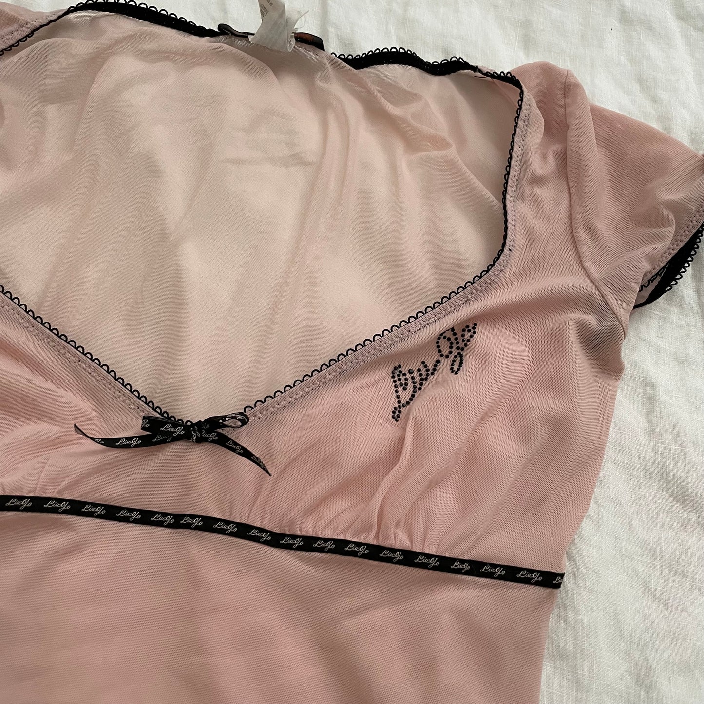 light pink liu jo cap sleeve sheer top with black picot trim and bow charm